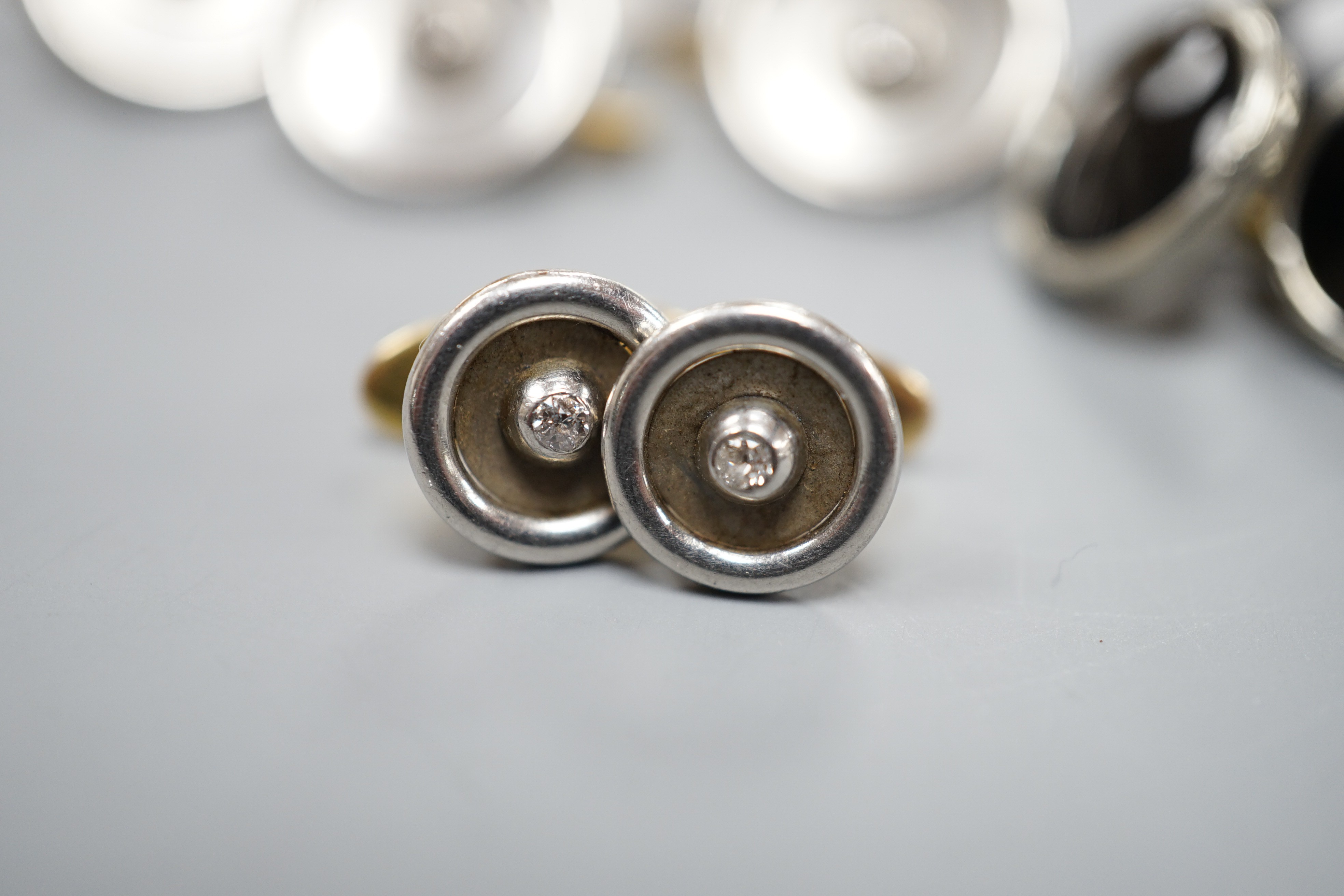 A pair of small pair of yellow and white metal diamond set cufflinks and four similar dress studs and four other yellow metal and black enamel? dress studs, gross weight 22.6 grams